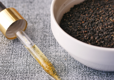 Damlalık şişede doğal çörekotu yağı ve yanındaki taze çörekotu tohumları