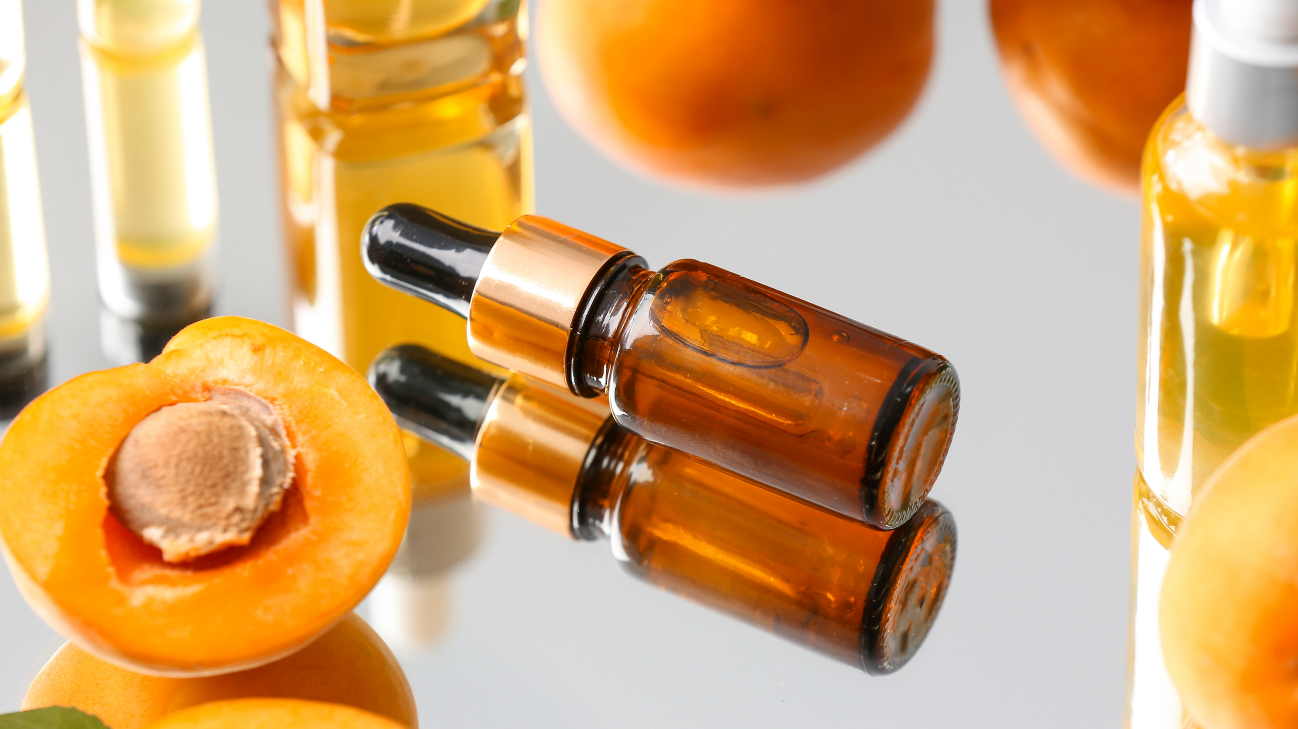 Damlalık şişede doğal kayısı çekirdeği yağı ve yanında taze kayısı çekirdekleri